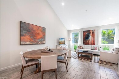 Dining room with high vaulted ceiling and wood finished floors
