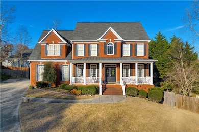 View of front of house with a porch, roof with shingles, a standing seam roof, brick siding, and a metal roof