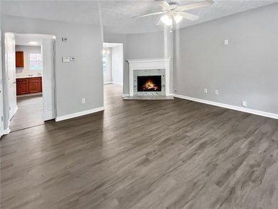 Unfurnished living room featuring a ceiling fan, d
