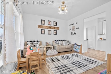 Living area with light wood-type flooring and a chandelier