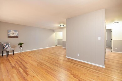 Another view of the Large Living Room OPEN to the Dining Room and looking into the Hallway area with 4 Bedrooms, all with Beautiful Hardwood Floors!