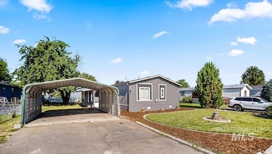 Manufactured / mobile home with driveway, a carport, a front yard, and crawl space