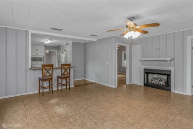 Living room featuring ceiling fan and crown moldin