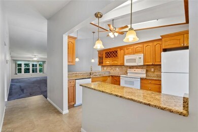 Kitchen featuring white appliances, ceiling fan, a