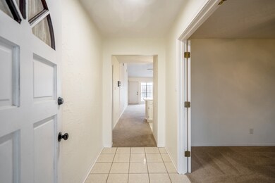 Let's head inside! This first view into the home we see the lovely neutral tile of the entrance & the transition to carpet leading out.