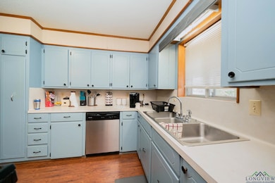 Kitchen featuring light countertops, a sink, dark 