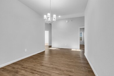 On the opposite end of the kitchen, a hallway leads in two directions, connecting to various areas of the home.