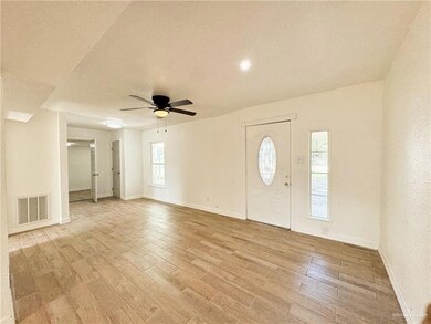 Foyer entrance with light hardwood / wood-style flooring, a textured ceiling, and ceiling fan