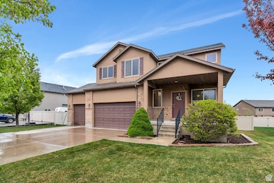 Craftsman-style home featuring covered porch, a front yard, a garage, fence, and stucco siding