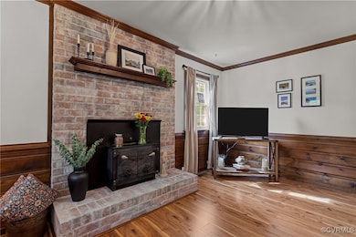 Living area featuring LVP, a wainscoted wall, orna