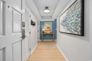 Corridor featuring a tray ceiling and light hardwood / wood-style flooring