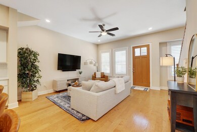 Living area with a ceiling fan, light wood-style 