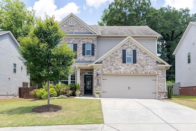 Traditional-style home featuring concrete driveway, brick siding, and an attached garage