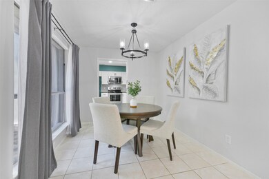 Gather for family meal times in this sunlit dining room that is situated between the kitchen and the family room. This room features tile floors, a stylishly updated modern-style chandelier, & an expansive window to the courtyard.