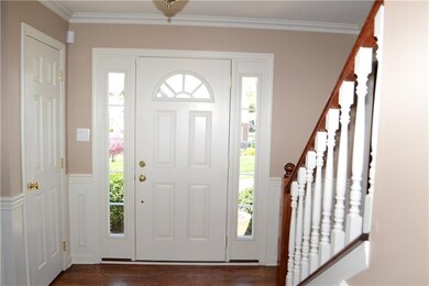 Entry with chair rail, crown molding, and hardwood