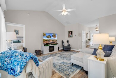 Living area featuring wood finished floors, a ceiling fan, baseboards, high vaulted ceiling, and a fireplace