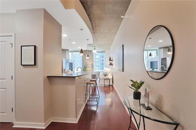 Hall featuring dark wood-style flooring and recessed lighting