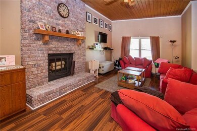 Brick hearth fireplace and wood plank ceiling adds