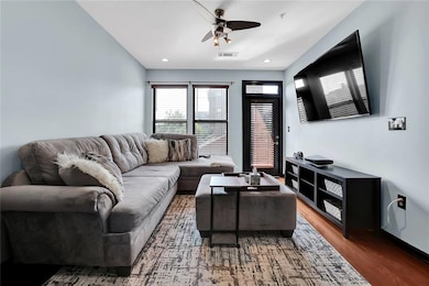 Living area featuring a ceiling fan, wood finished floors, and recessed lighting