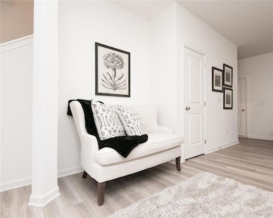 Sitting room featuring light wood-type flooring and baseboards