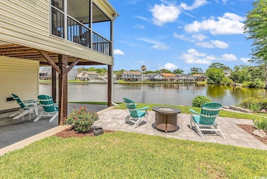 View of green lawn featuring a patio, and a water view
