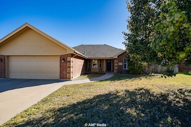 Single story home with brick siding, driveway, a front yard, and an attached garage