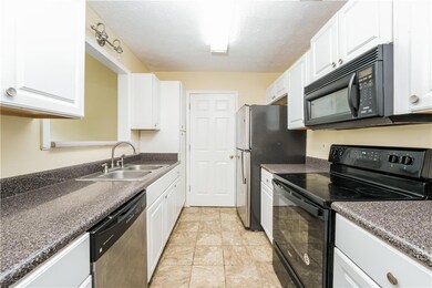 Kitchen with black appliances, a sink, white cabinetry, dark countertops, and a textured ceiling