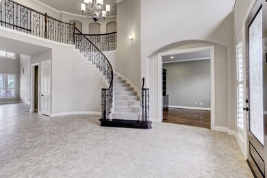 Upon entering the home, you will see the curved staircase with the gorgeous iron details and the high ceiling. This entryway offers access to multiple rooms, including the study and formal dining room.