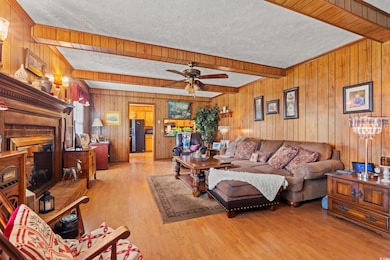 Living area featuring wood walls, a ceiling fan, a