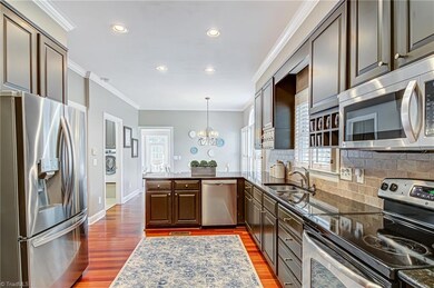 The kitchen features recessed lighting, granite countertop, lots of cabinetry, tile backsplash, and stainless appliances.