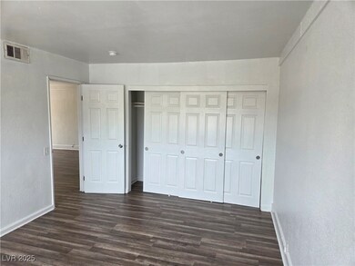 Unfurnished bedroom with baseboards, dark wood fin