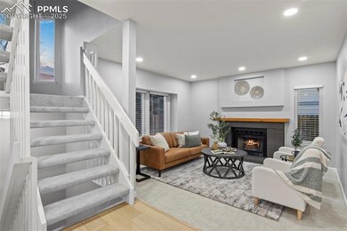 Living room featuring a brick fireplace, stairs, w