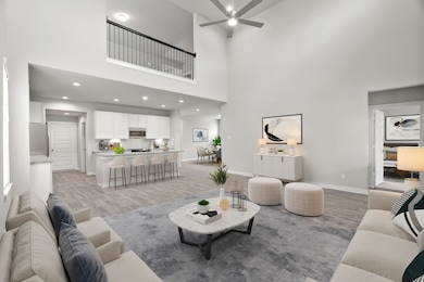 Bring your loved ones and guests together in the inviting living room! Boasting lofty high ceilings, recessed lighting, a stylish ceiling fan, custom paint, stunning flooring, and expansive windows that flood the space with ample natural light all day long. Sample photo of completed home. As-built color and selections may vary.