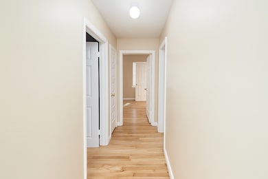 Hallway featuring baseboards and light wood finished floors