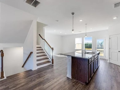 Kitchen featuring pendant lighting, dark stone counters, dark brown cabinets, dark wood finished floors, and recessed lighting
