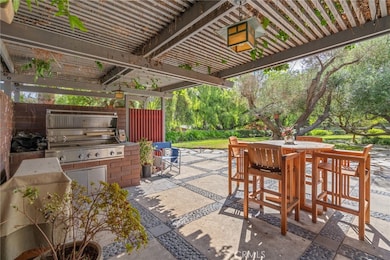 Deck off of kitchen with wisteria covered pergola