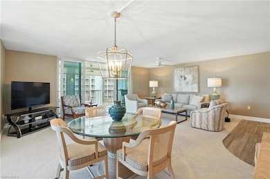 Carpeted dining area featuring a chandelier and baseboards
