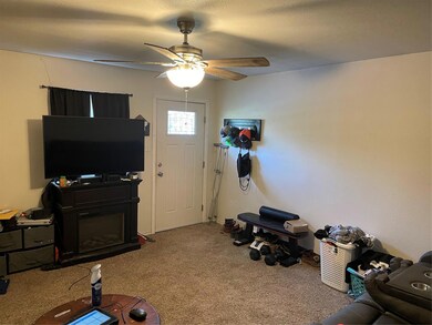Carpeted living room with ceiling fan