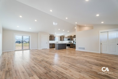 Unfurnished living room featuring light wood-style flooring, recessed lighting, and high vaulted ceiling