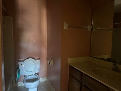 Bathroom featuring baseboards, vanity, toilet, and