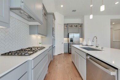 Kitchen with pendant lighting, sink, light hardwoo