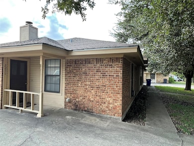 View of property exterior featuring brick siding and a chimney