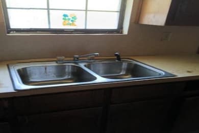 Kitchen view of a sink and light countertops
