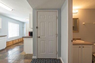 Bathroom featuring vanity, stone tile flooring, and a textured ceiling