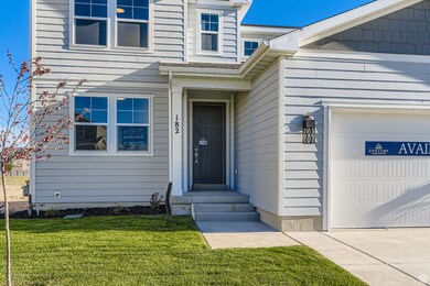Property entrance featuring a garage and a lawn