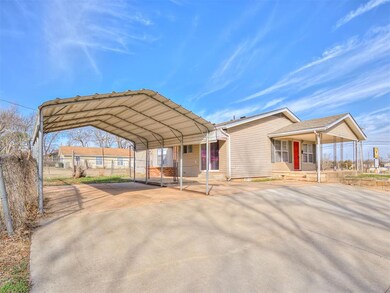 View of front of house with a carport and covered 