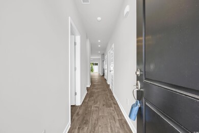 Corridor featuring wood finished floors and recessed lighting