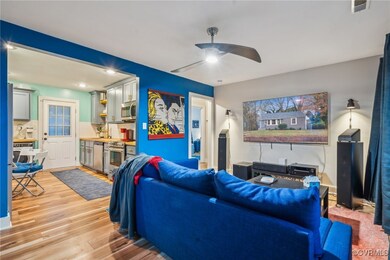 Living room with ceiling fan and light wood-type f