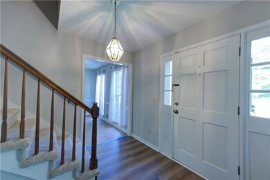 Foyer entrance featuring stairs, dark wood finished floors, and plenty of natural light
