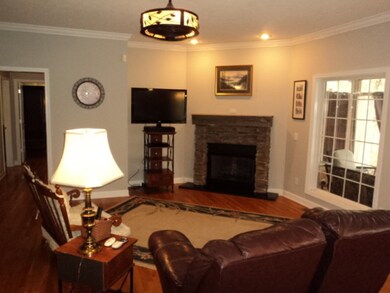 The living room is open to the kitchen and features a stone faced gas fireplace